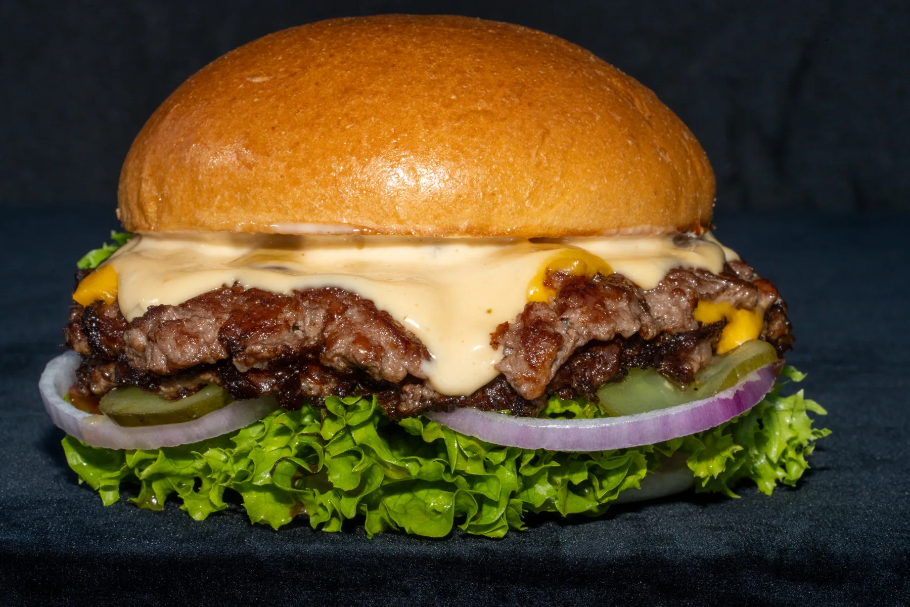 Cheeseburger photographed on a dark food photography backdrop