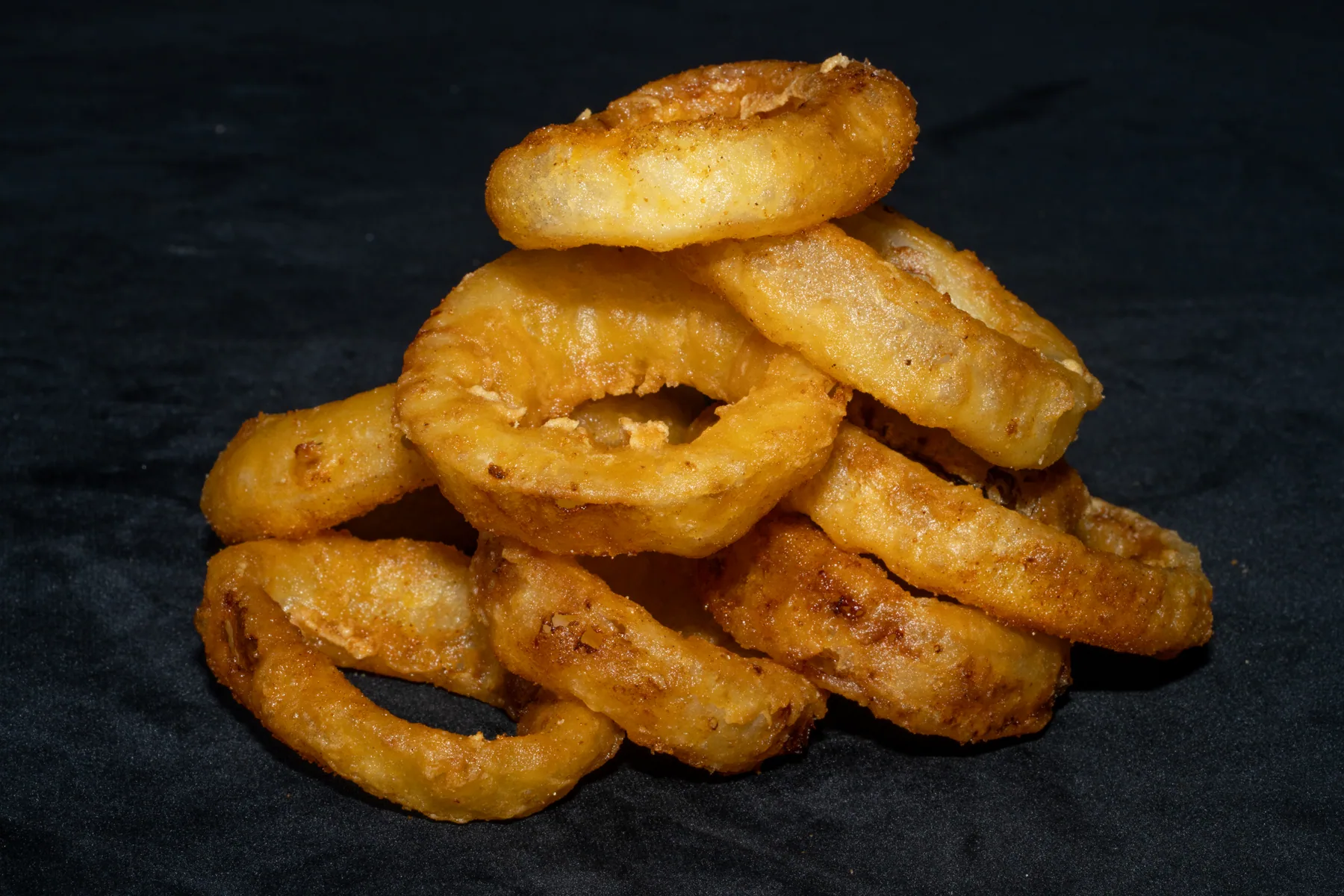 Onion rings photographed on a dark food backdrop
