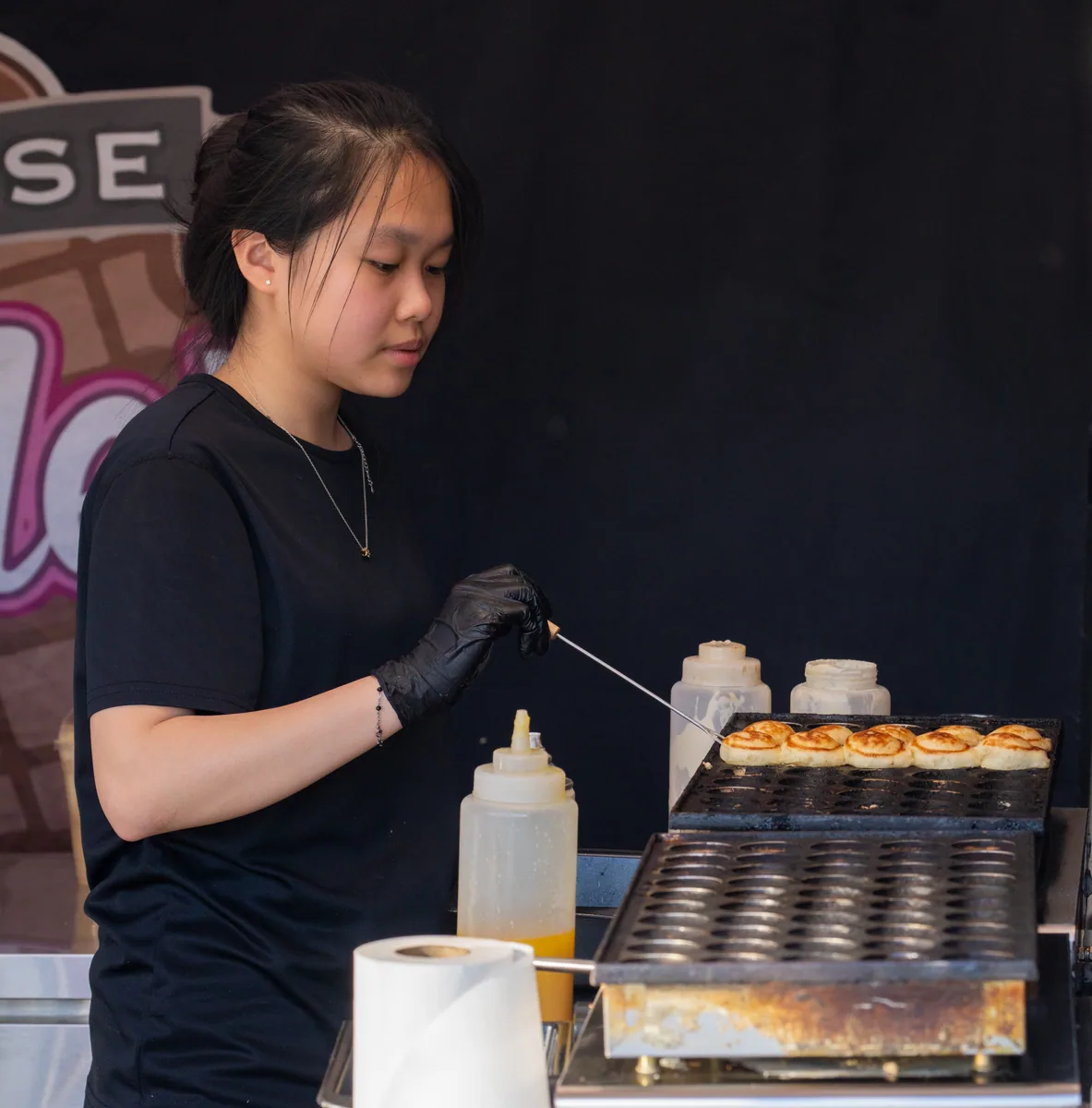 Dessert vendor preparing food at a market stall