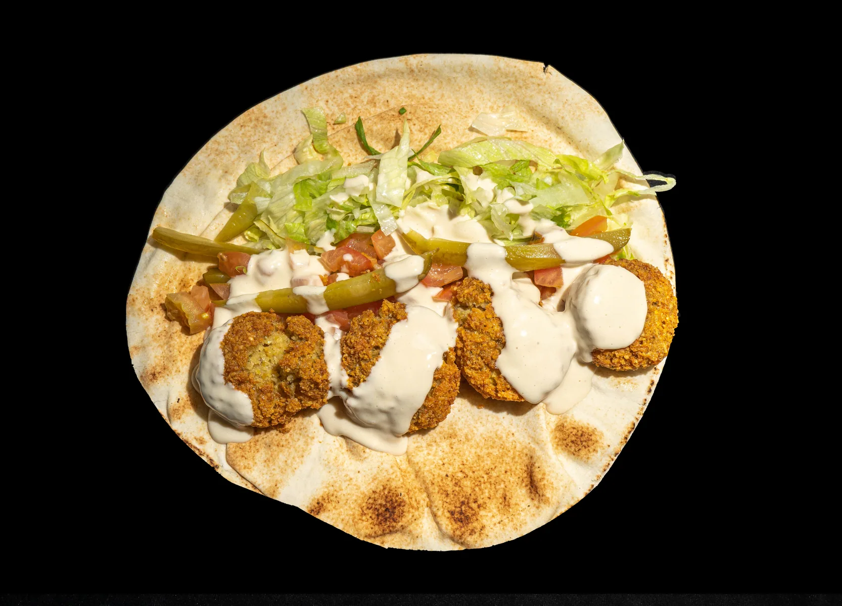 Falafel wrap photographed on a dark background for menu photography